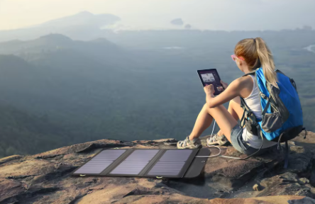 Aventurera cargando con panel solar portátil en plena montaña